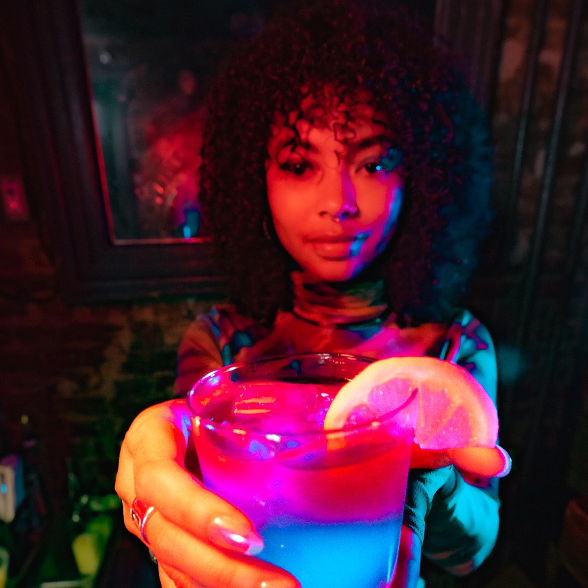 A model presents the blue BLUE MOE drink with a lemon slice during the Easy Lover commercial shoot